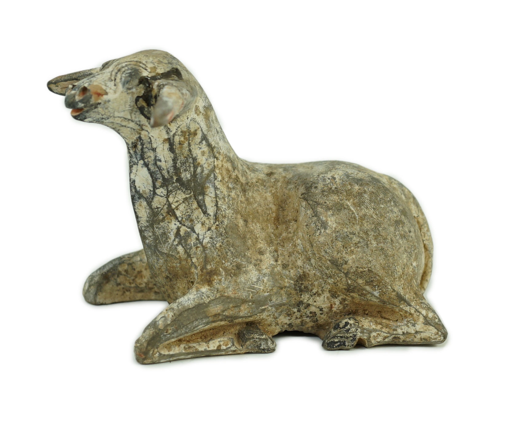 A Chinese painted grey pottery model of a recumbent sheep, Han dynasty, 10.2 cm long, One ear re-glued